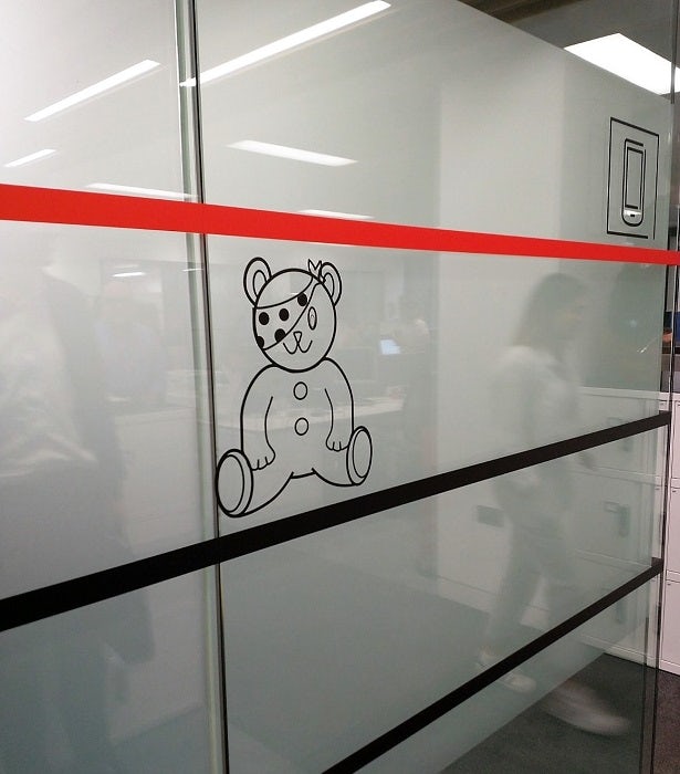 A glass-walled meeting room, with the Children In Need mascot Pudsey Bear adorning the side.