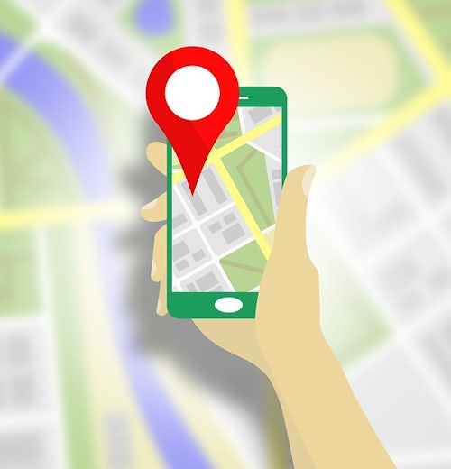 Vector graphic showing a hand holding a mobile phone with a location pin and a map on the screen.