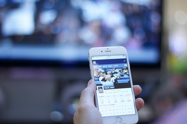 Person using a mobile phone while watching TV