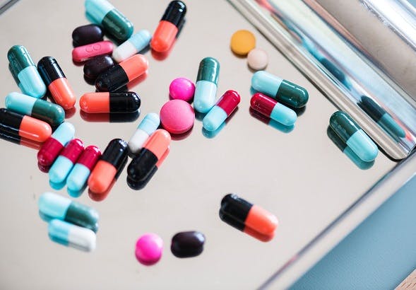 Stock image of colourful pills on a clipboard.