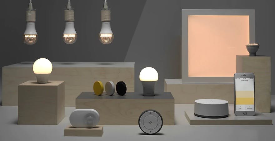 An array of smart lighting products by IKEA, together with a smartphone and devices to control them.