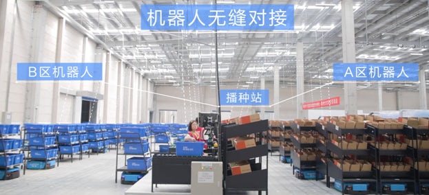 Promotional image of a large warehouse with crates and boxes sitting on black shelving units.