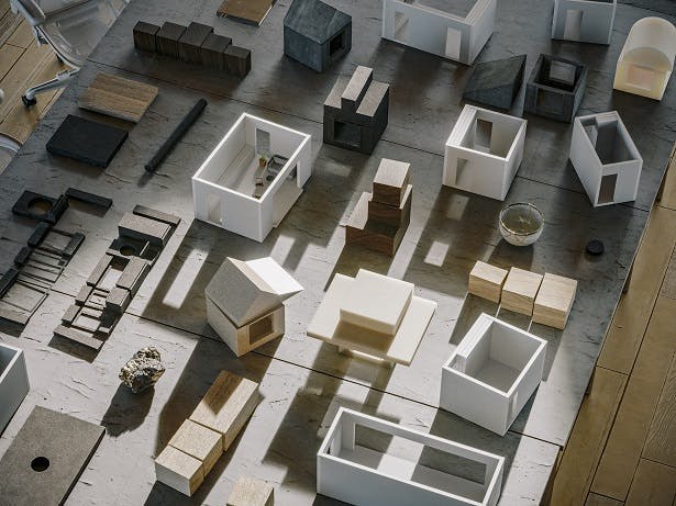 Numerous small housing models laid out on a wooden surface