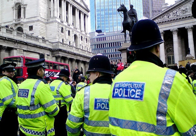 A police line in central Lodon, taken at an anti-capitalist demonstration in London in 2009. The officers in the photograph are shown from behind, wearing fluorescent yellow jackets emblazoned with Metropolitan Police.