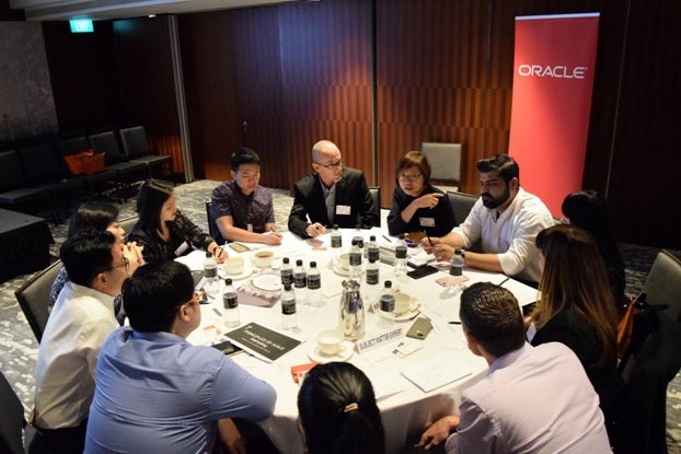 Attendees at Econsultancy's Digital Cream roundtable event discuss agile marketing, with an Oracle banner behind their table.