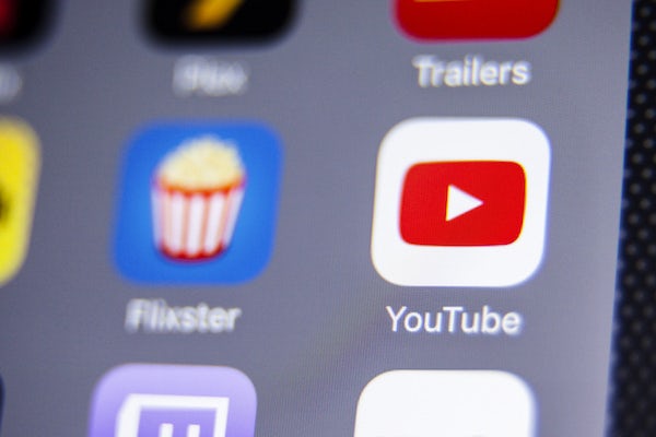 Macro closeup image of Youtube app icon among other icons on an iPhone smartphone device.