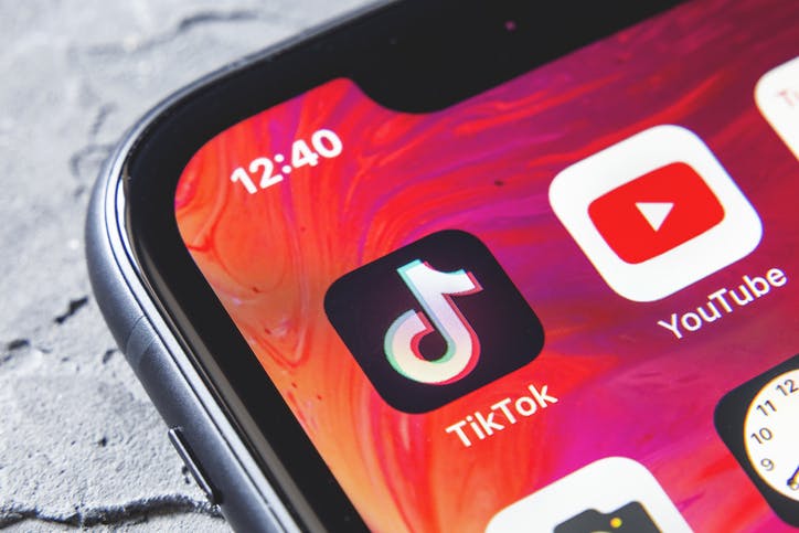 The corner of a smartphone screen showing the TikTok app next to the YouTube app and other icons.