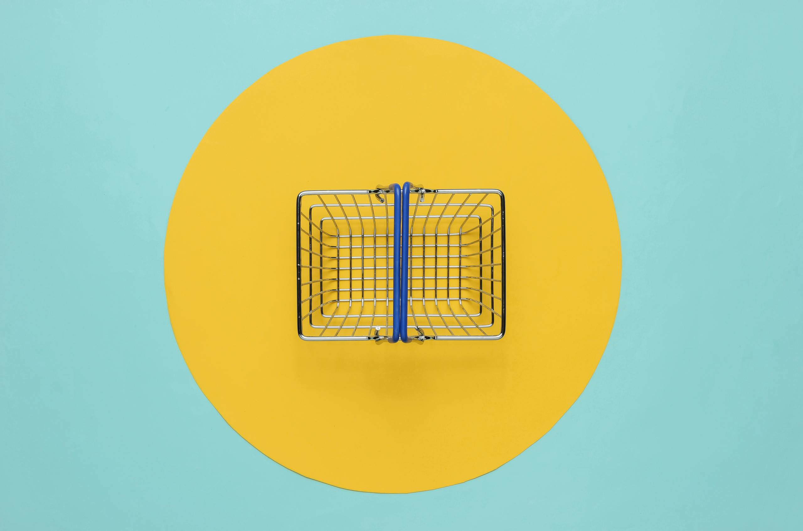 Mini shopping basket on blue background with yellow circle