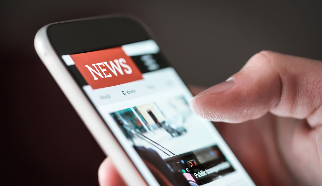 man looking at news on mobile phone