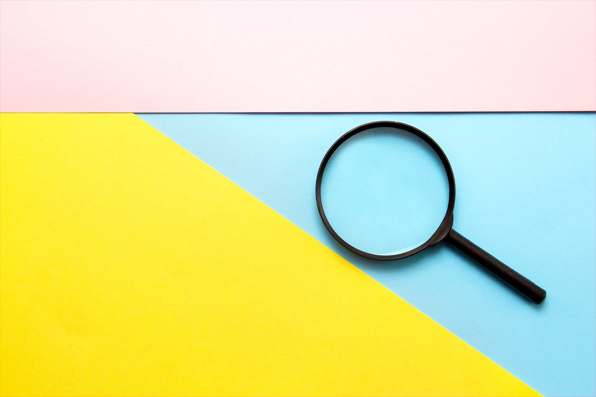 Magnifying glass on blue pink yellow background