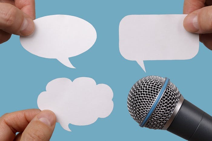 Microphone surrounded by speech bubbles