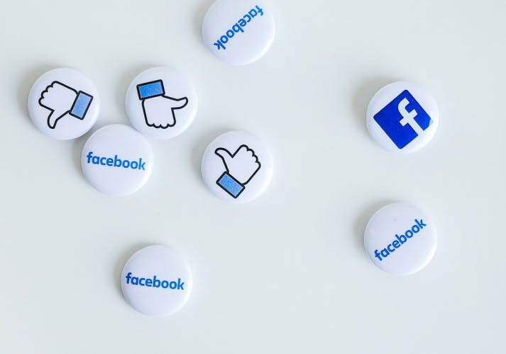 facebook icon pins badges scattered on white surface