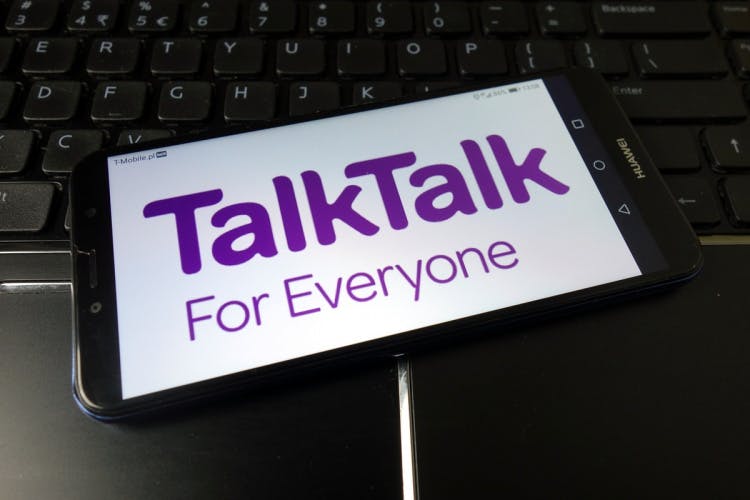 Talktalk徽标和口号显示在计算机键盘上的手机上。