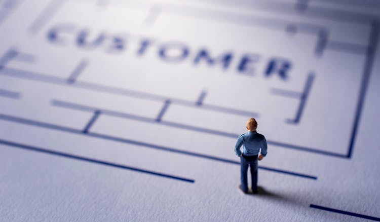 miniature model of a man on paper with word 'customer'