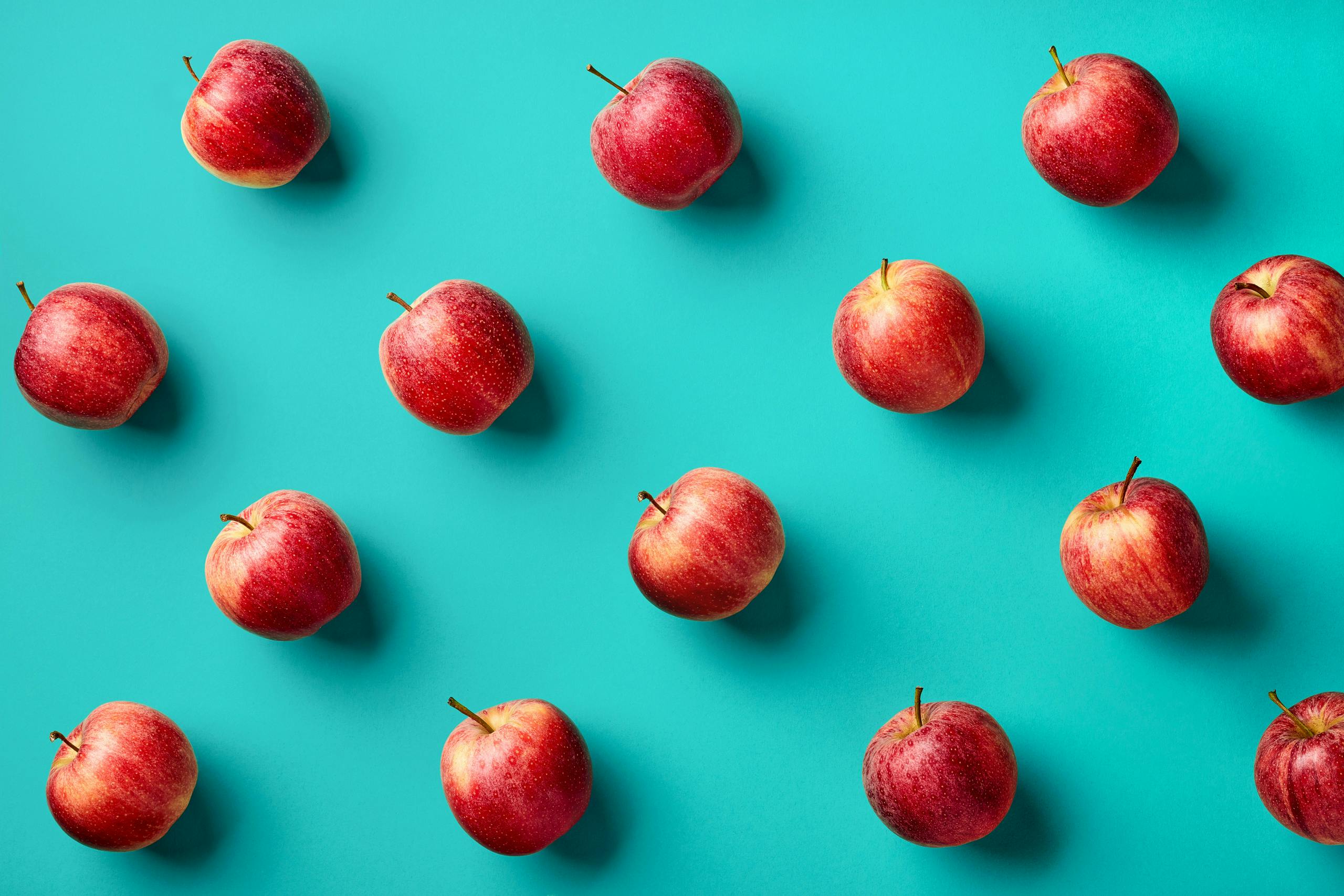 red apples in a diagonal grid pattern upon a turquoise background