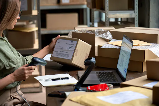Stock photograph of a worker scanning the barcode on a parcel.