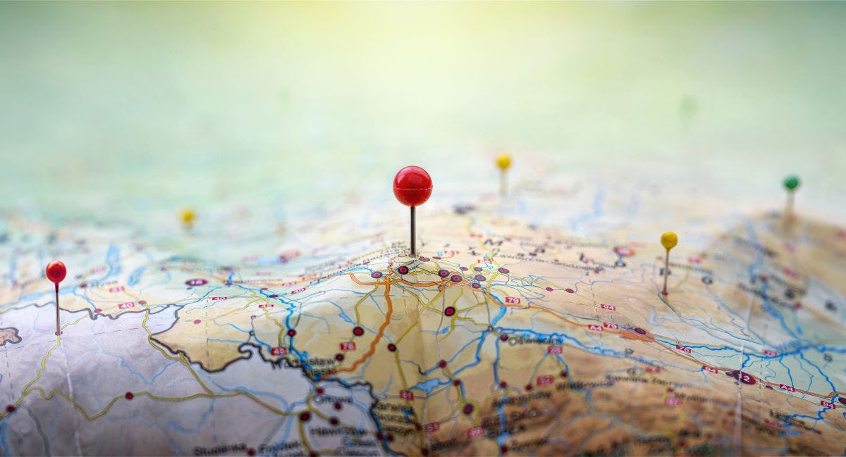 red, yellow and blue pins in geographic paper map