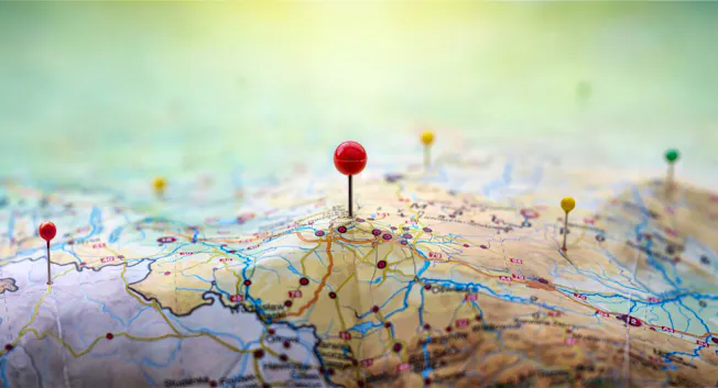 red, yellow and blue pins in geographic paper map