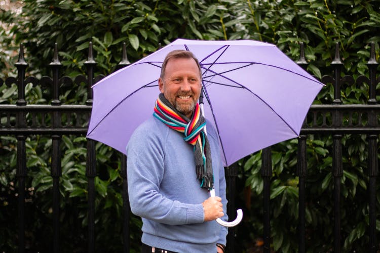 Headshot of Stuart Hodge holding a large umbrella