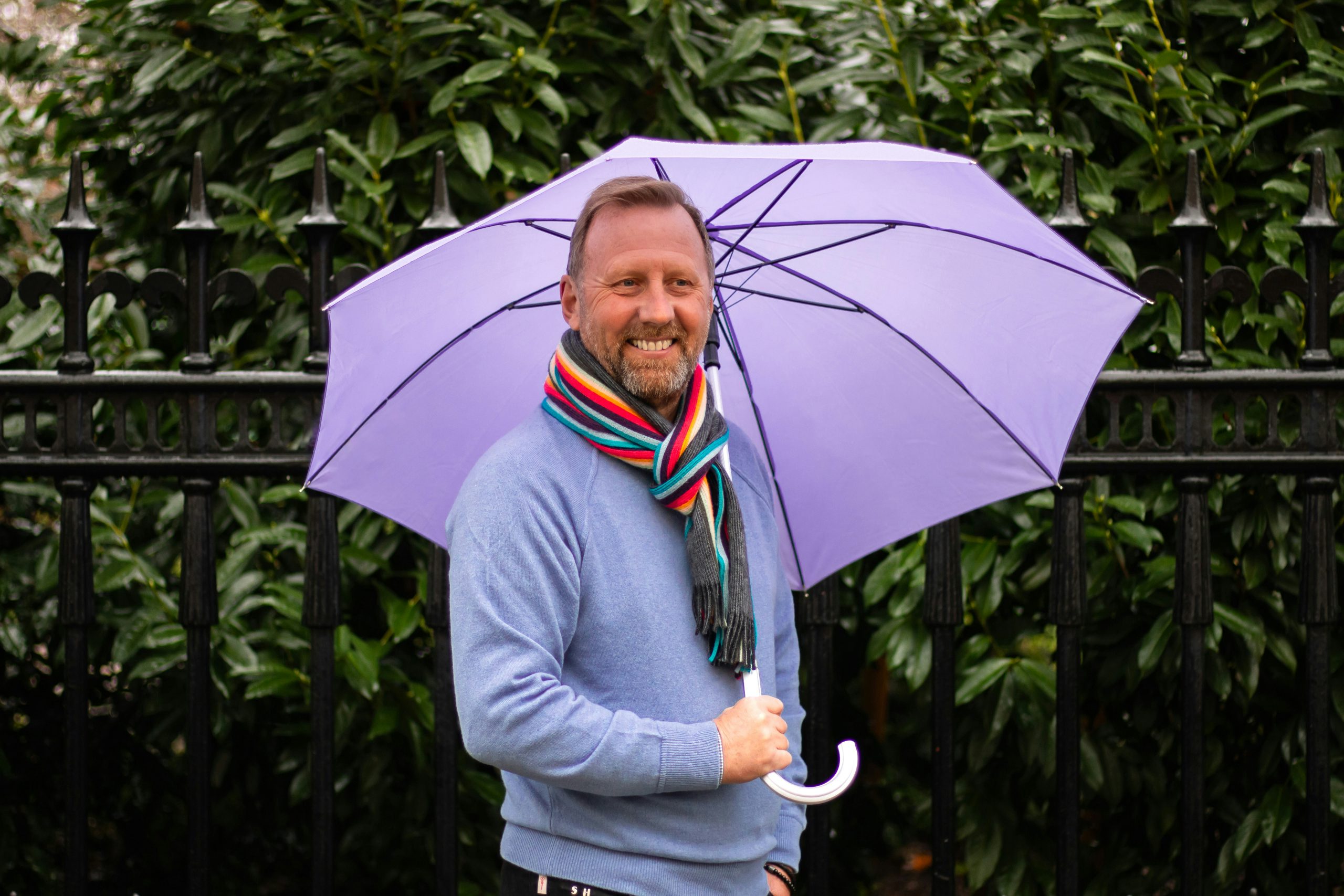 Headshot of Stuart Hodge holding a large umbrella