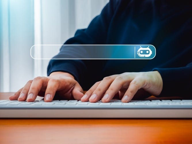 A pair of hands typing on a keyboard with a search bar above that has a robot icon at one end.