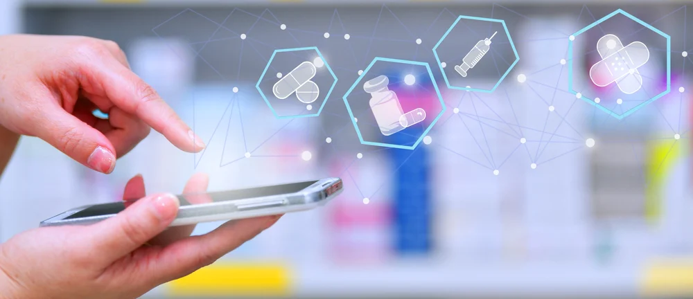 Hand using smartphone with pharmaceutical icons.